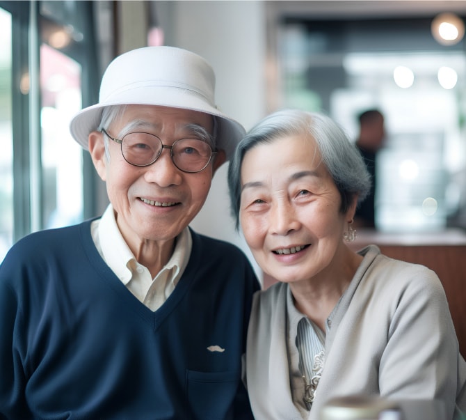 年配の夫婦がこちらを向いて微笑むイメージ写真